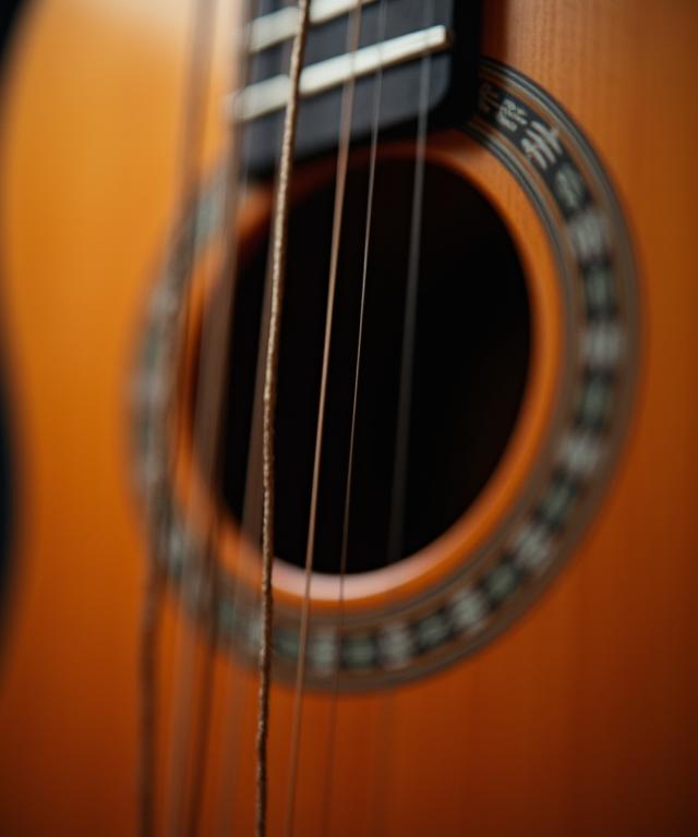 A close-up of an acoustic guitar's soundhole and strings.